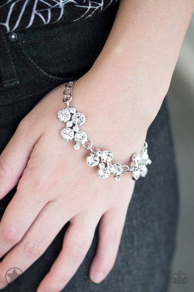 Clusters of brilliant white rhinestones drape elegantly along the wrist. The scattered pattern and varying sizes of the rhinestones add breathtaking detail to the piece. Features an adjustable clasp closure.